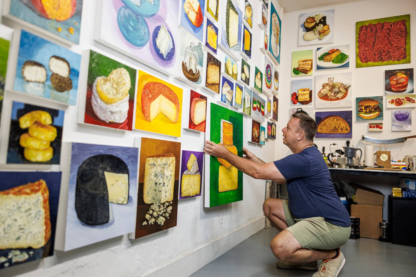 Artist Mike Geno with his wall of cheese portraits