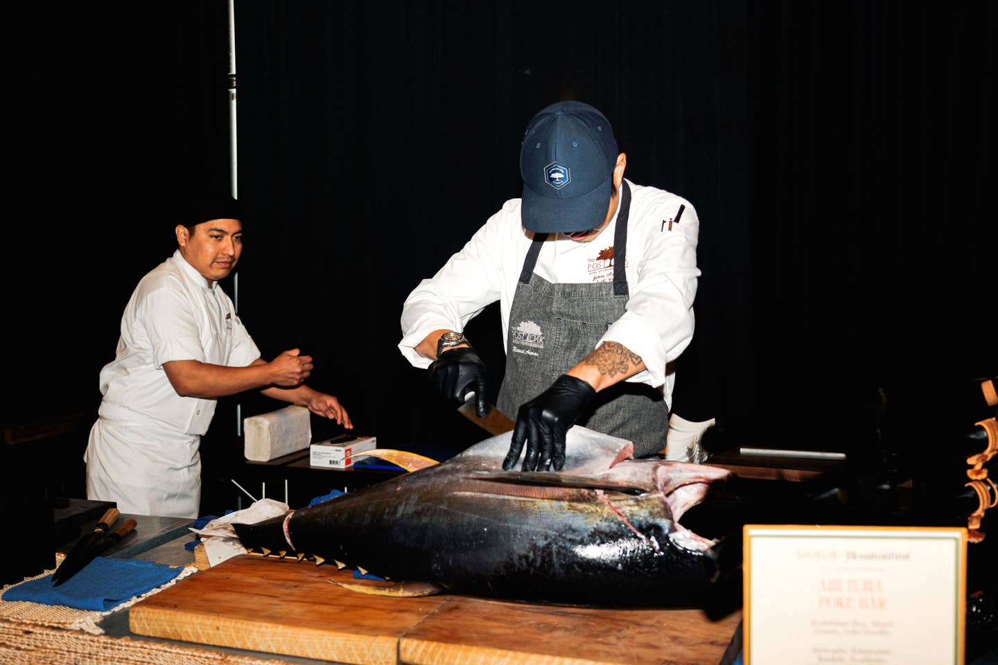 Chefs at the raw bar break down a whole tuna.