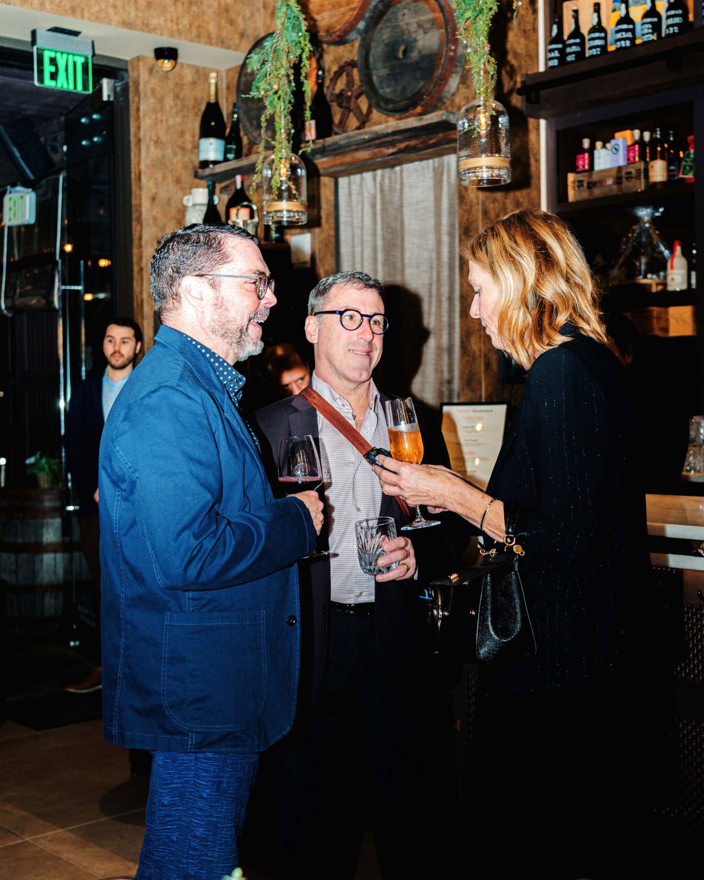 Steven Tesney, Grant Caplan, and Jennifer Evans Gardner share a drink.