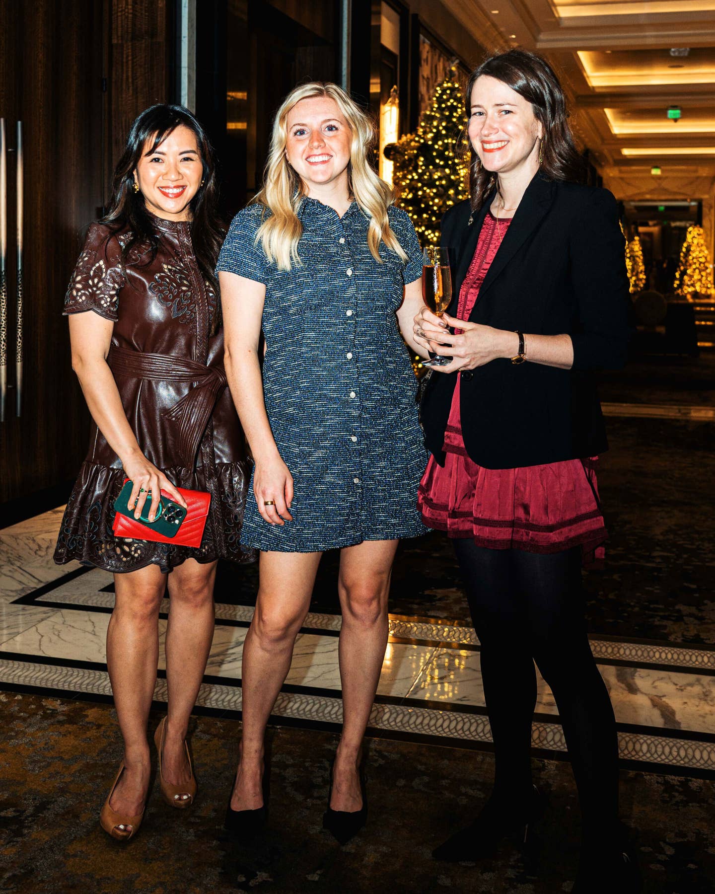 Three women in cocktail attire in the lobby of Houston's Post Oak Hotel.