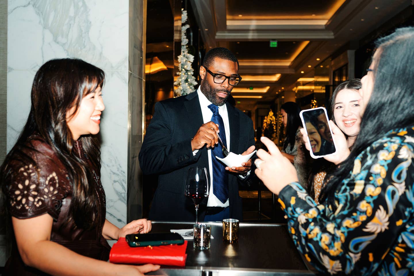 Pitmaster Greg Gatlin, surrounded by other party guests, samples the evening’s fare.