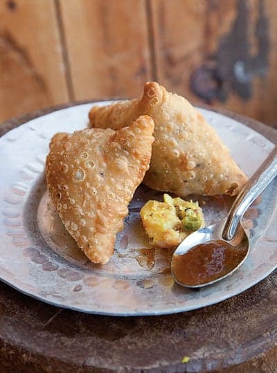 Indian fried samosas filled with spiced potatoes, onion, and peas