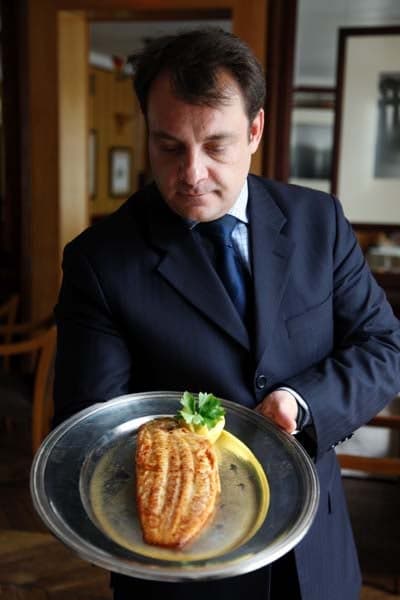 A waiter serves sole meuniere at Le Bistrot Paul Bert Paris