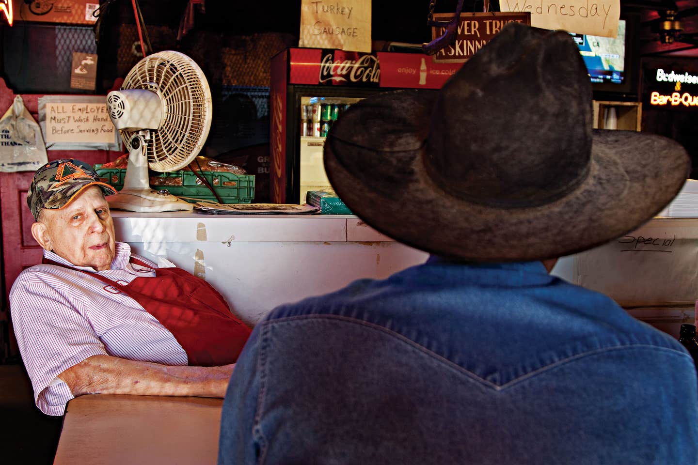 Vencil Mares, owner of Taylor Cafe in Taylor, Texas, relaxes behind the bar of the restaurant.