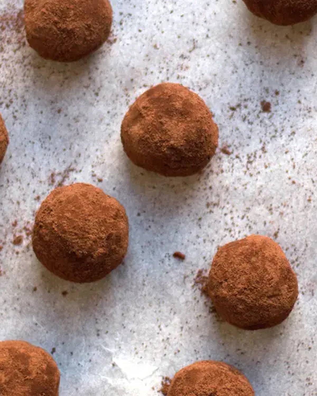 Chocolate Amaretti Truffles on a parchment-lined sheet pan.
