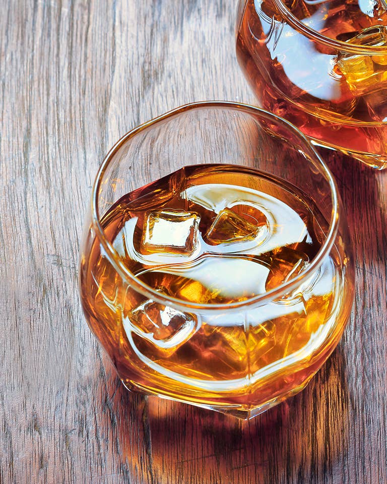 Glass with Whiskey on table rustic wooden background, top view