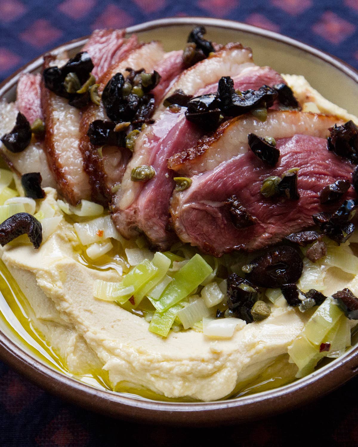 Hummus with Pan-Seared Duck, Leeks, and Tapenade
