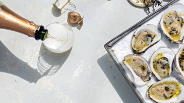 Grilled Oysters on a Bed of Salt with a bottle of Champagne