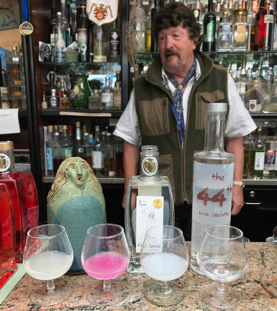 The granite-topped bar and the shelving behind it are littered with filled absinthe vessels and vintage memorabilia.