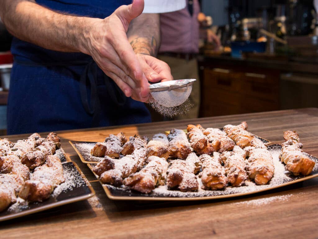 These pistachio sacristains get a healthy sprinkling of powdered sugar