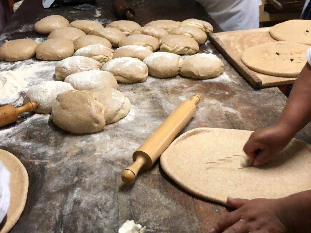 The bakers use a special razor blade to decorate their loaves.