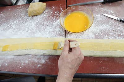 brushing dumpling dough with egg wash