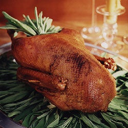 Whole steam-roasted goose on a platter of sage.