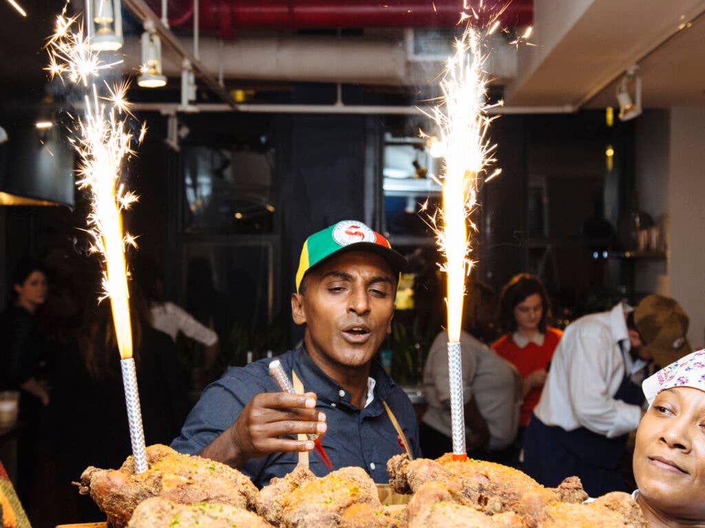 Marcus Samuelsson sets up sparklers on a platter of fried chicken