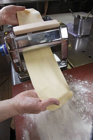 rolling dumpling dough through pasta machine