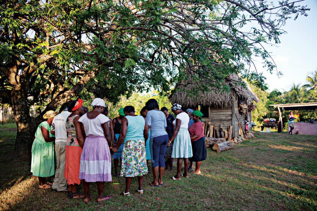 Members of a cassava bread producing cooperative share a prayer in Ciriboya, Honduras