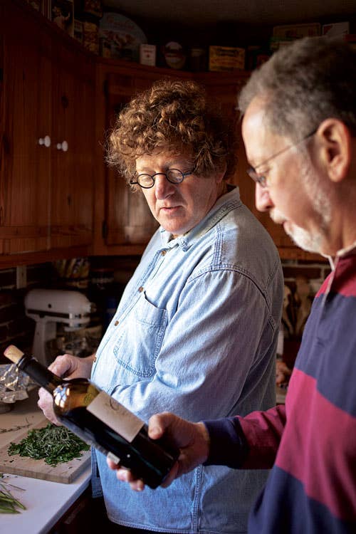 man and woman looking at wine bottle