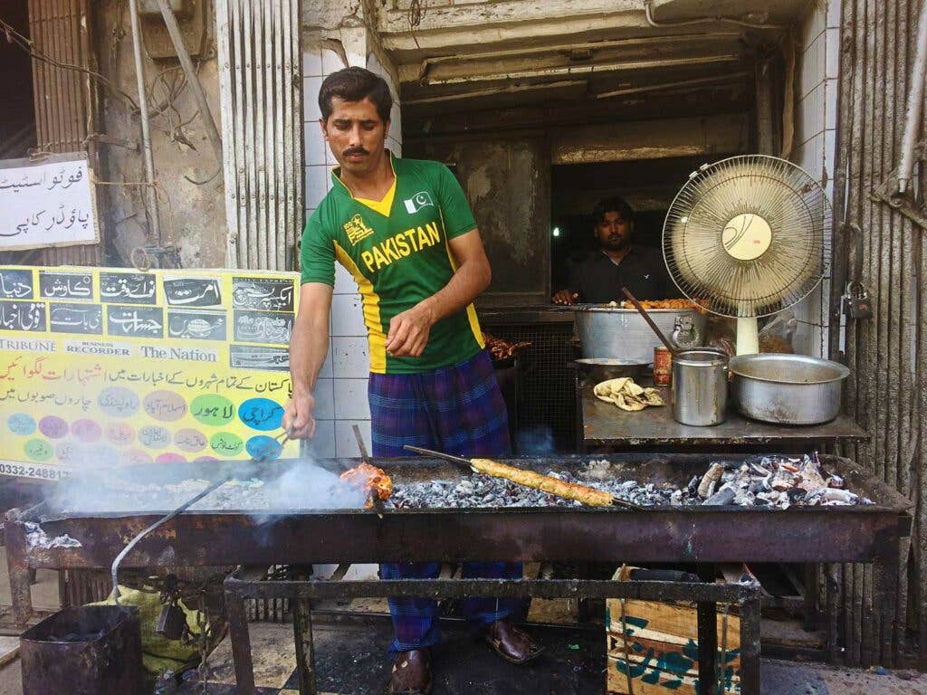 A charcoal grill is set up behind the cafe for barbecuing kebabs.