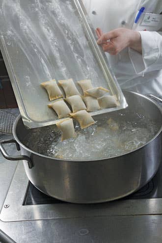 plunging dumplings into boiling salted water