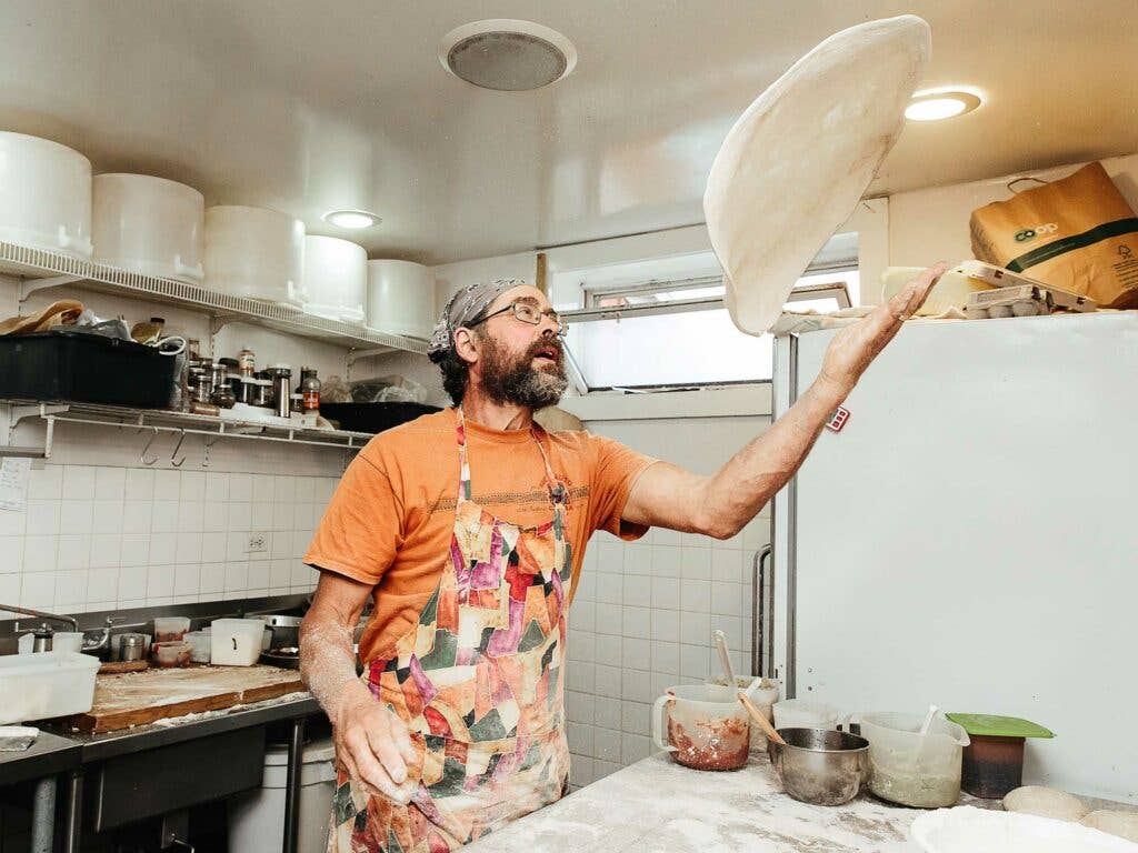 A to Z's Ted Fisher tossing dough in the bakery.