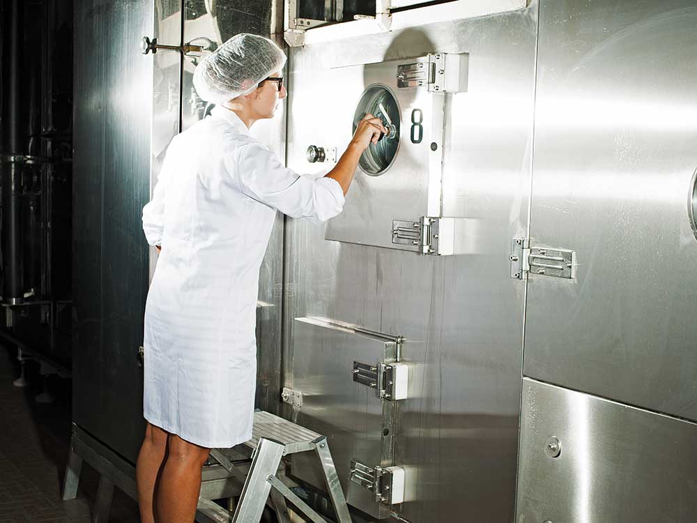 A quality-control assistant checks the flow of spaghetti during the machine’s drying process.