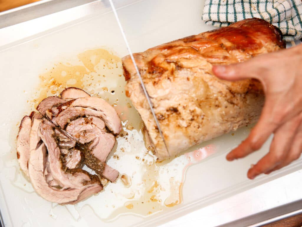The moment everyone was waiting for: the porchetta is sliced, to be served with chicharrónes