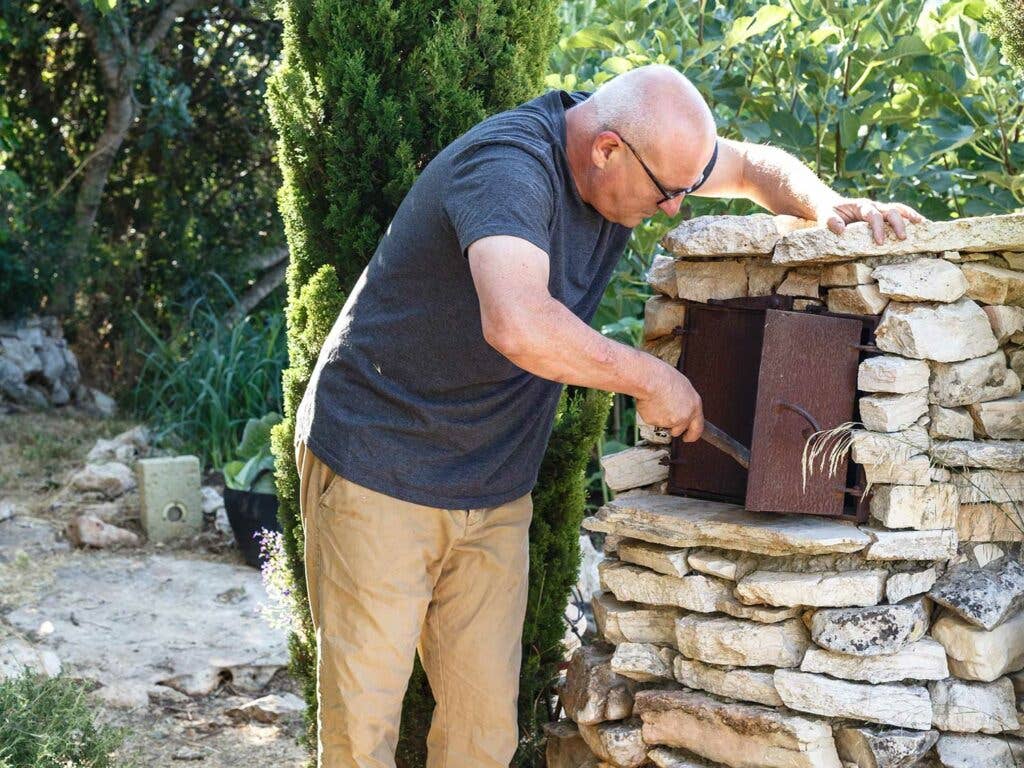 Komarovsky cooking out of one of the ovens in his garden