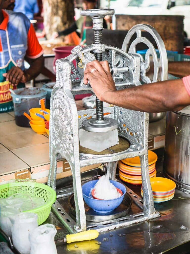 Vendor shaving ice for cendol