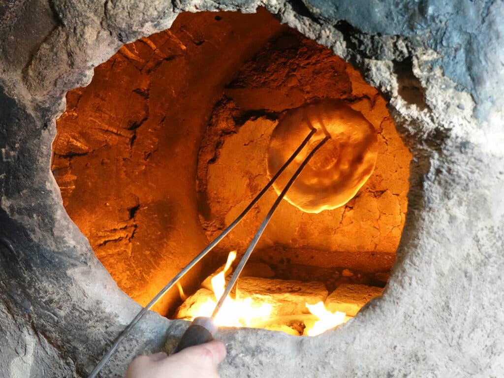 removing traditional Afghan naan from a tandoor