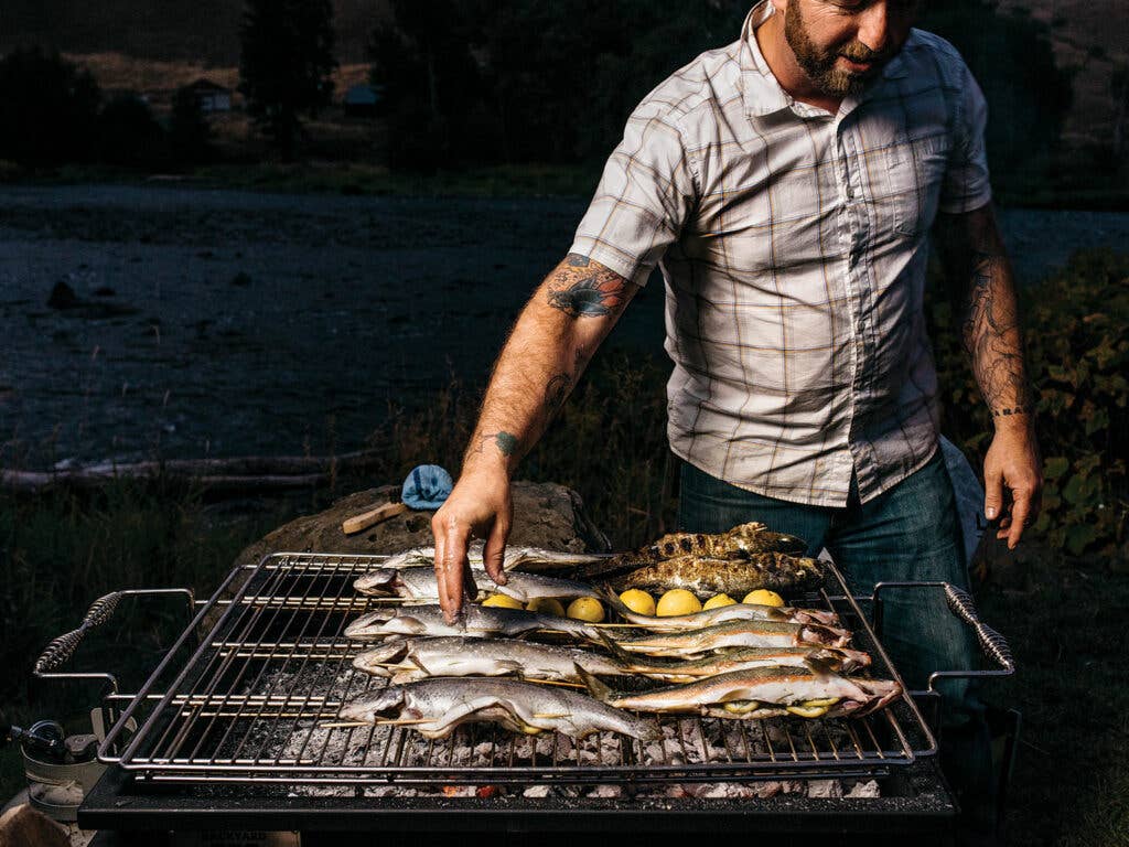 Elias Cairo tending to fish and lemons on grill