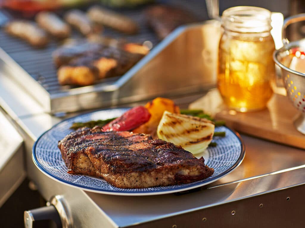 plate of grilled steak and vegetables on summer day