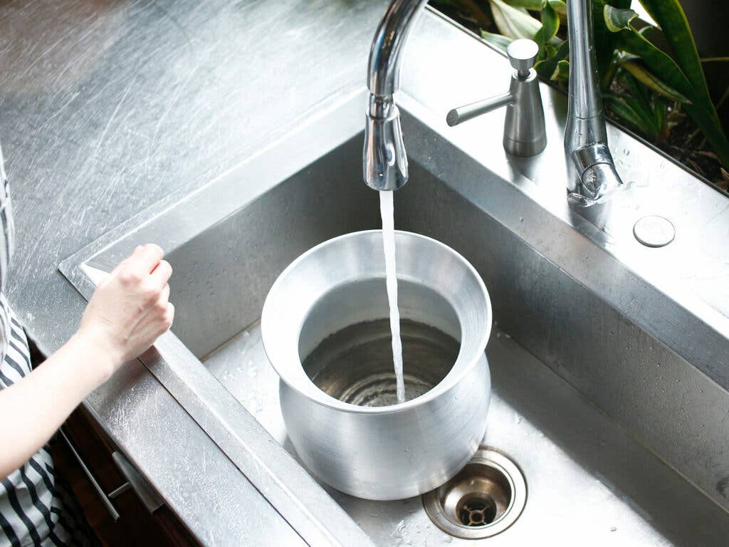 running water from the faucet into rice steamer pot