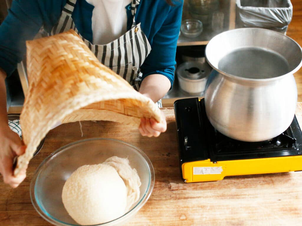 cheesecloth wrapped rice bundle dropped into glass bowl