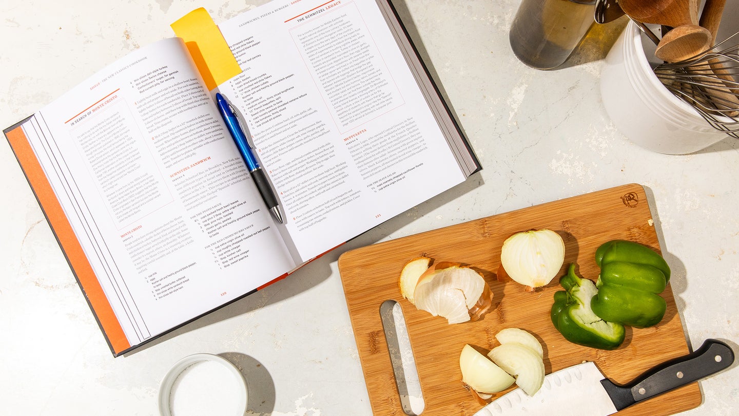 open cookbook with veggies on the cutting board