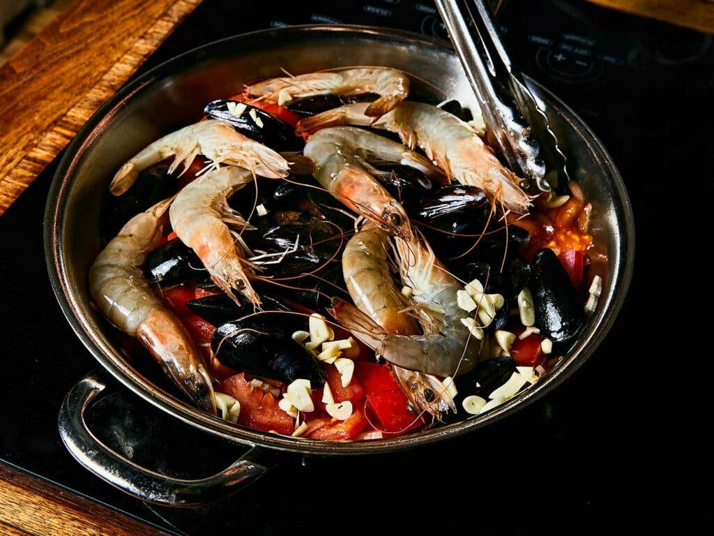 Seafood Pasta with Tomatoes, Chiles, and Mint in skillet.