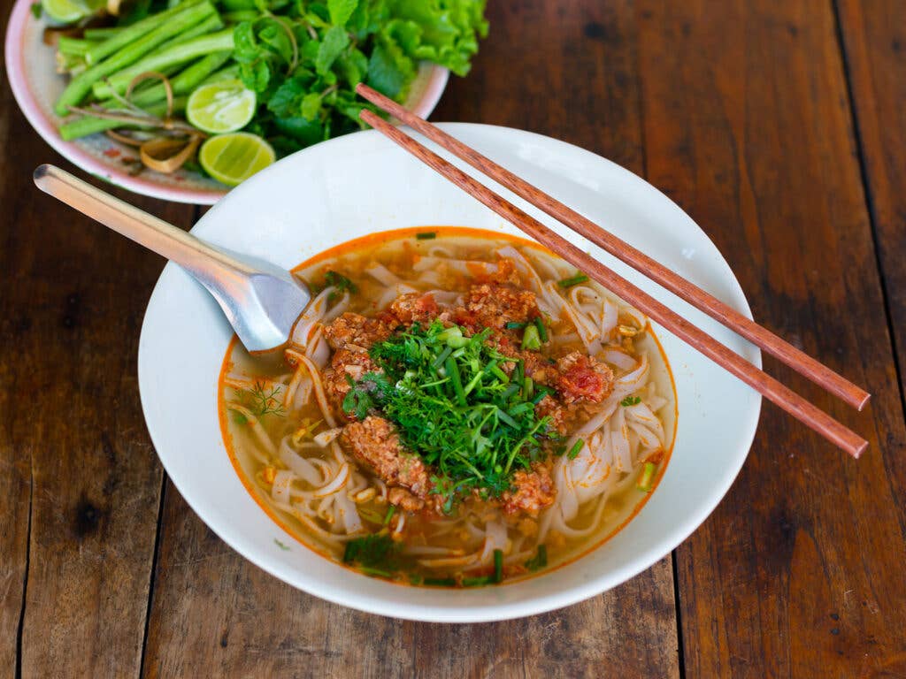 Khao soi in bowl with chopsticks.