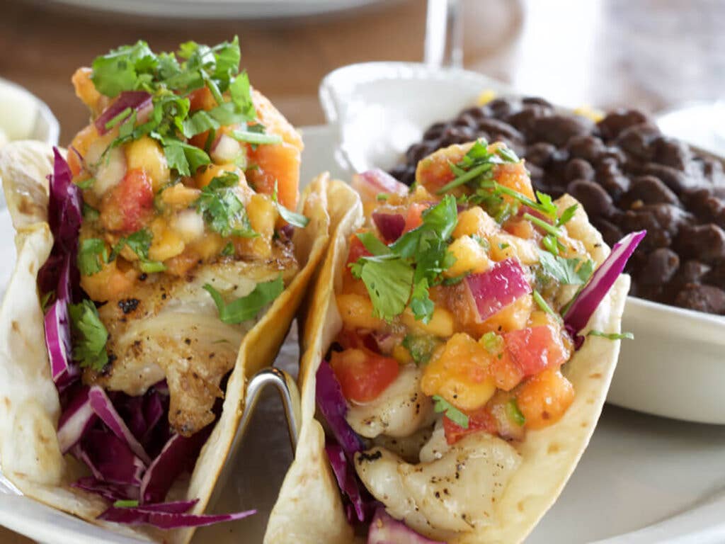 Pink shrimp tacos with rice and beans.