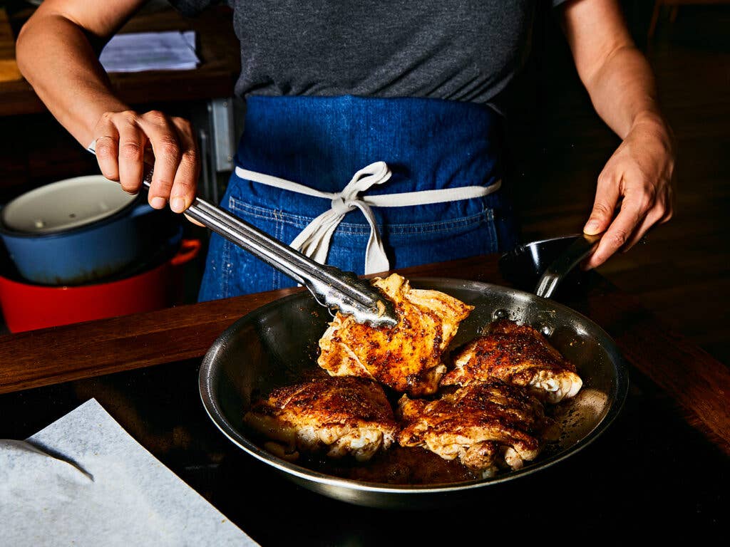 Searing chicken in skillet.