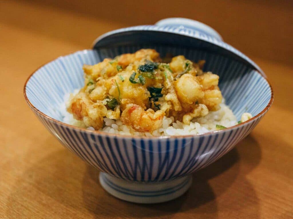 A bowl of rice is crowned with fritter-like prawn and scallop kakiage and doused in hot green tea just before serving.