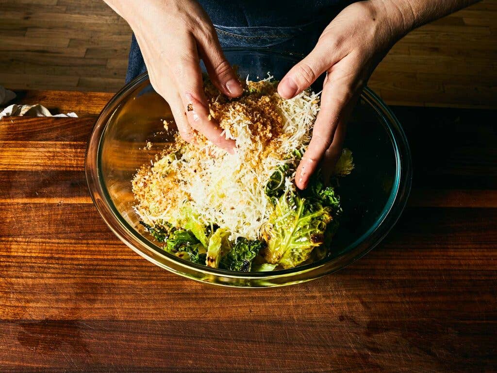 Mixing in vinaigrette, bread crumbs, and grated aged pecorino.