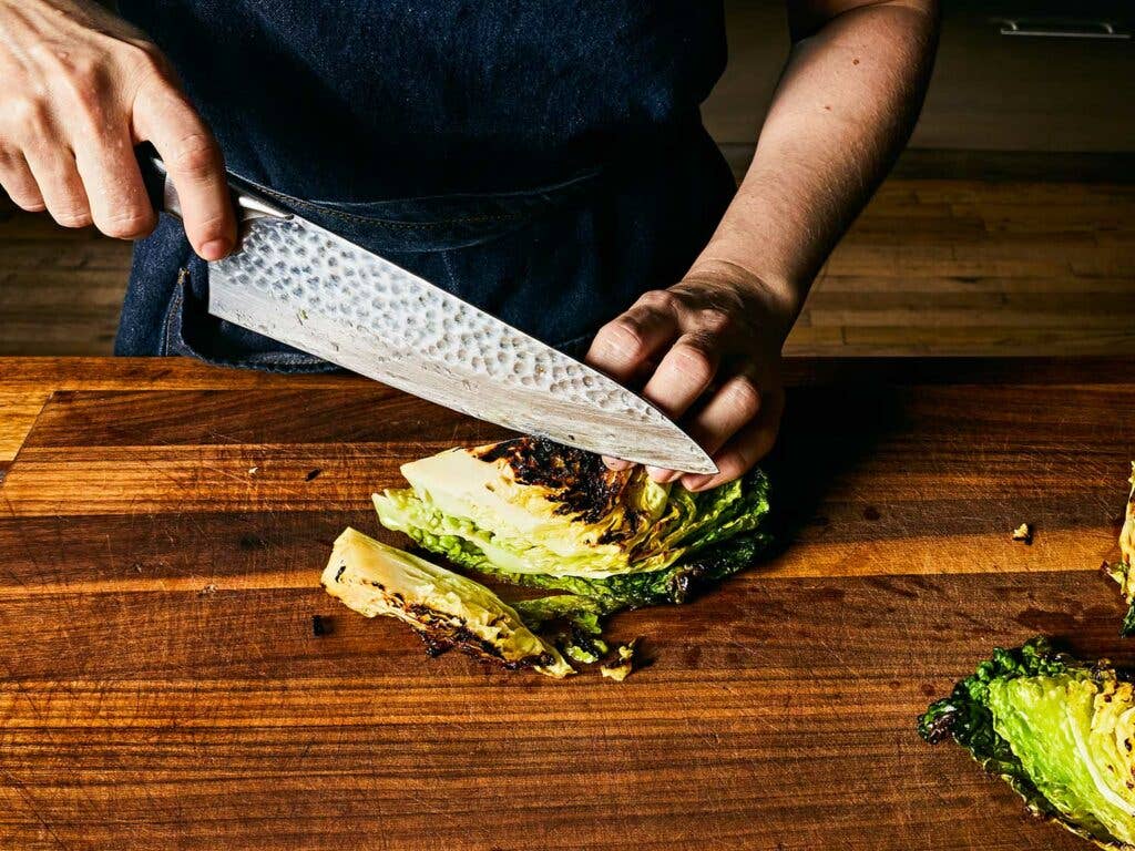 Cutting caramelized cabbage into generous strips for the salad.