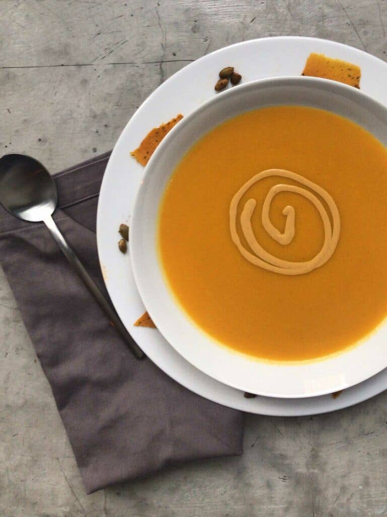 Smoked pumpkin soup spiked with Scotch bonnet chiles and garnished with a swirl of coconut cream.