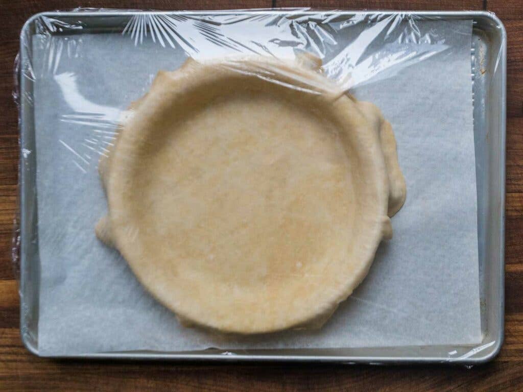 Pie crust covered with plastic wrap.