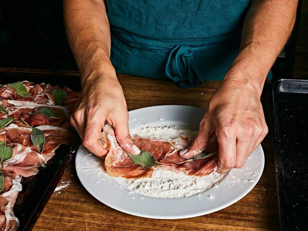 Veal cutlet covered in flour to help the veal brown and add body to the pan sauce.