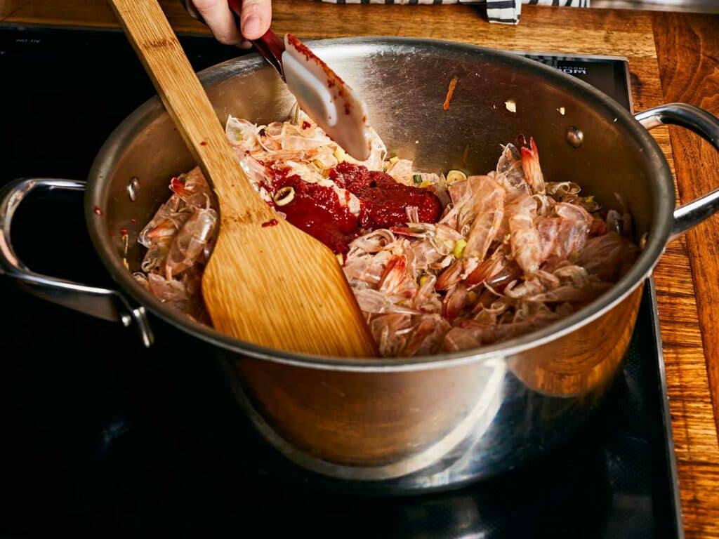 Tomato paste stirred into pot.