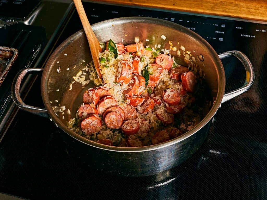 Toasting the rice in the fat of the andouille sausage. Toasting the rice in the fat of the andouille sausage.