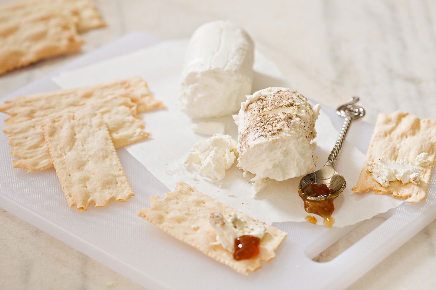 White Plastic Cutting Board With Cheese and Crackers