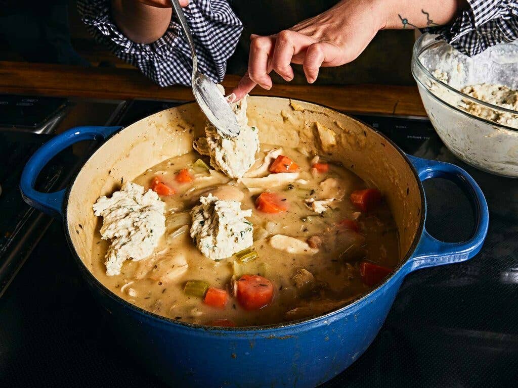 Dropping batter into stew to make dumplings.