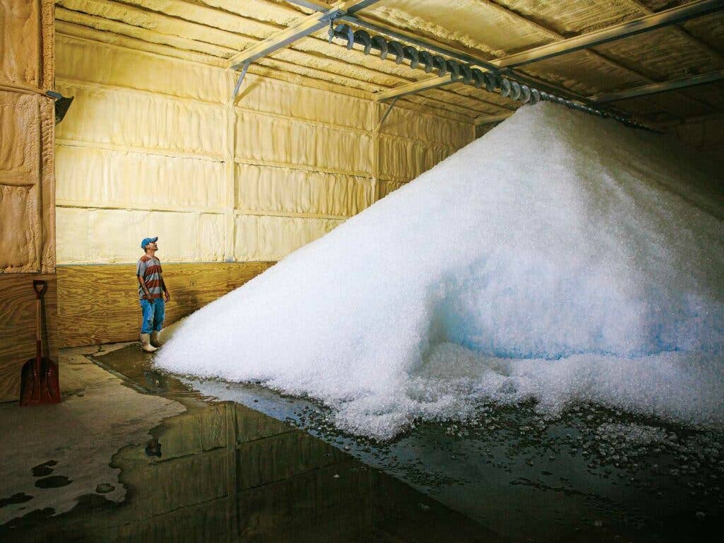 A massive pile of ice inside a refrigerated seafood storeroom.