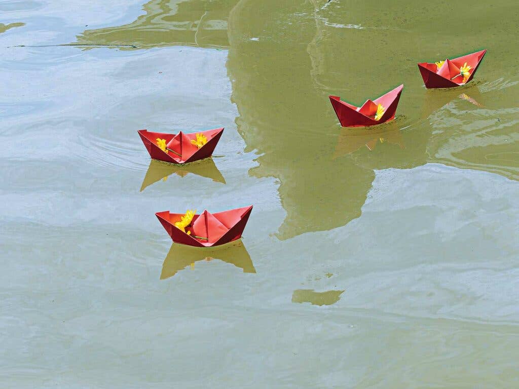 Paper boats are released for luck at the annual Blessing of the Fleet.